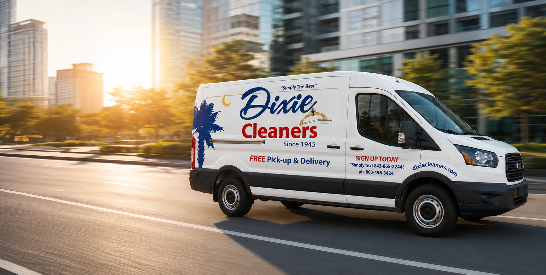 White delivery van with "Dixie Cleaners" and contact info on the side, driving on a city street with modern buildings and sunlight in the background.